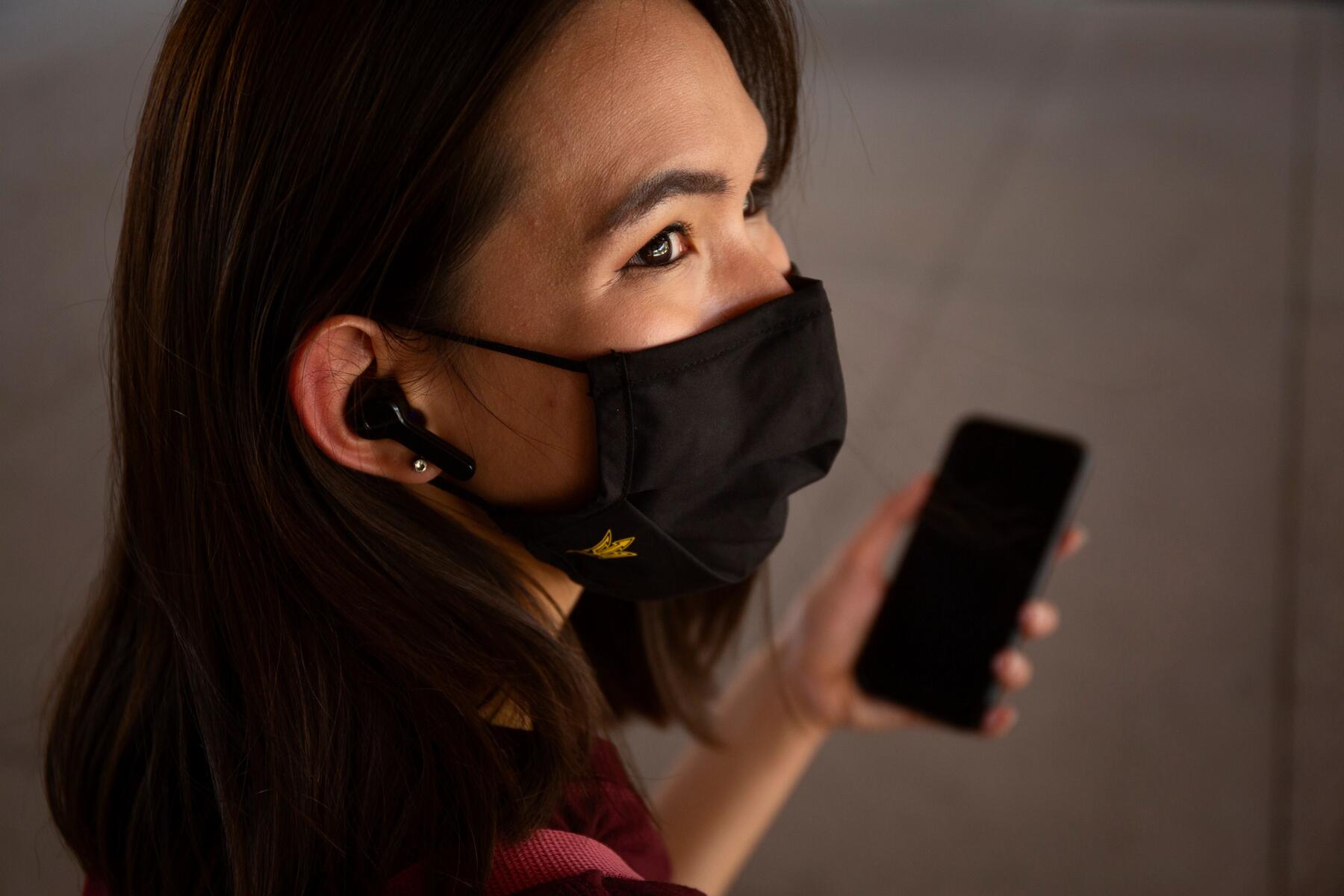 Woman in mask with phone